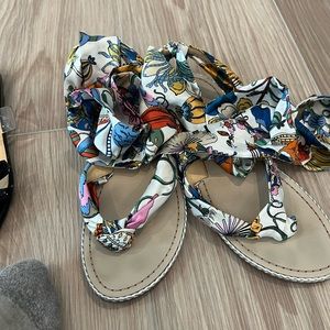 Printed flat louboutin sandals. Tie at ankle. Flower print.